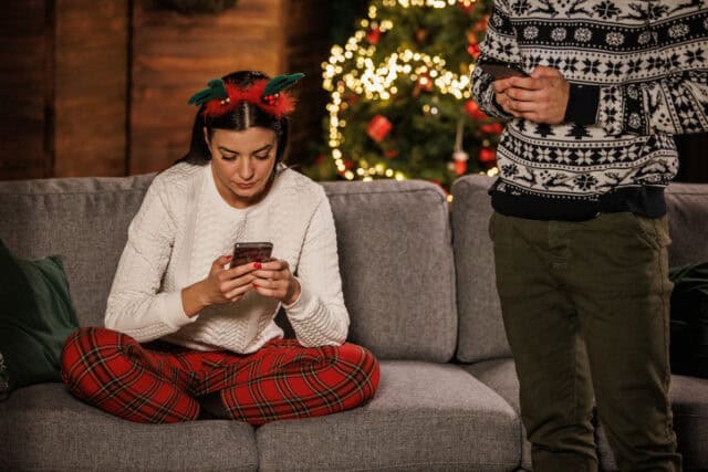 woman texting on couch at christmas