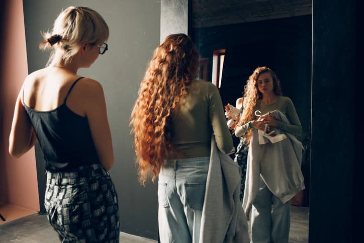 Woman helping one another get dressed.