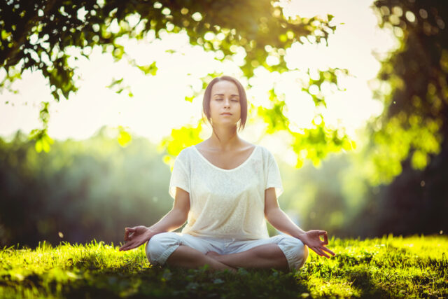 Young girl doing yoga in the park