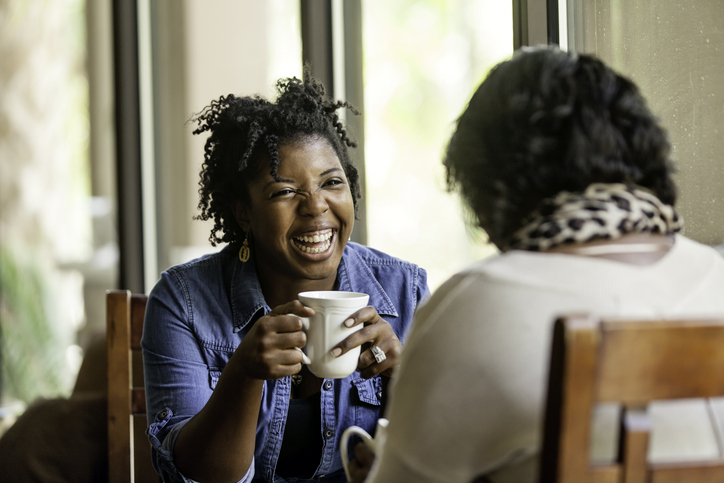 Two female friends chatting over coffee.
