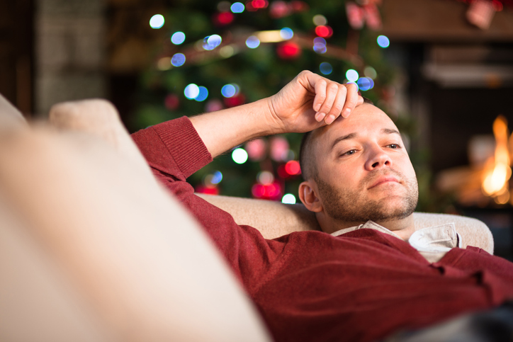 Fed up guy on couch at Christmas.