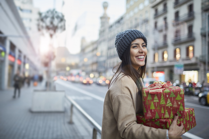 Woman carrying a Christmas present in the city.