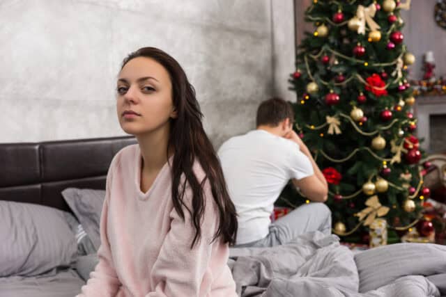 upset woman in bed on christmas