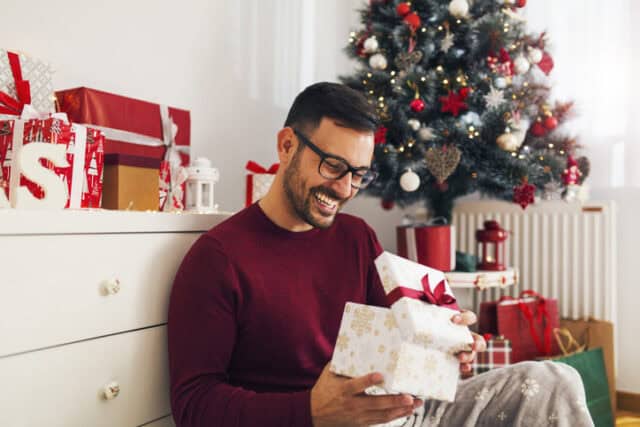 guy opening presents in christmas gift