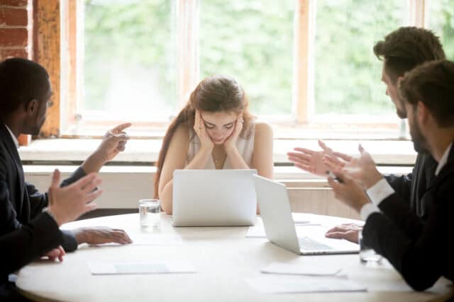 upset woman looking at laptop during meeting