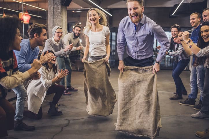 colleagues having potato sack race at office