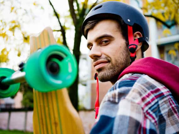 Portrait of young man with longboard