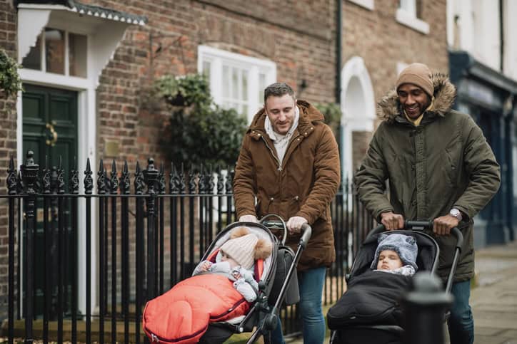 Two men walking with baby strollers.
