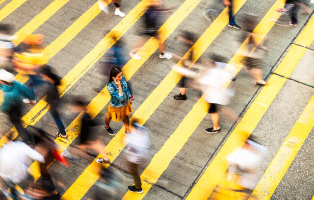 Pedestrians crossing a busy street intersection.