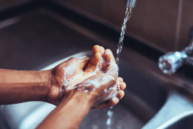 Man washing his hands at the sink.