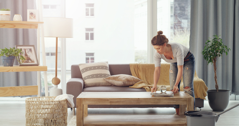 Young woman cleaning her living room.