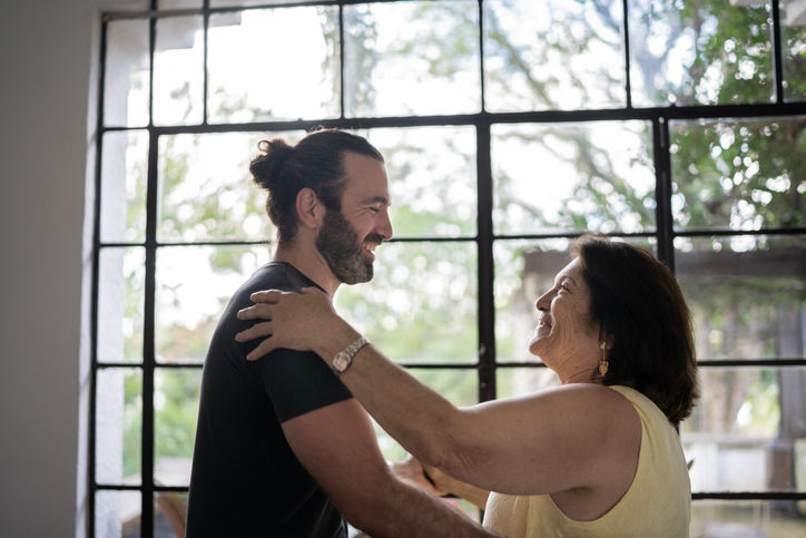 Adult man dancing with his mom.