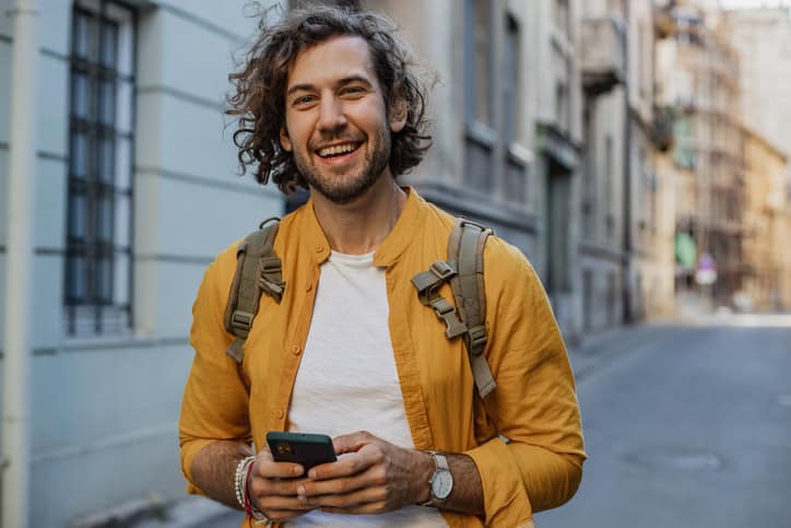 Young man walking on the street and smiling.