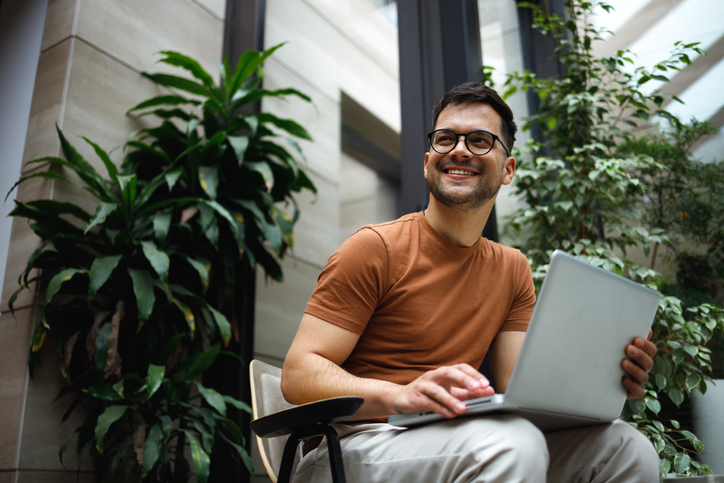 smiling successful businessman on laptop
