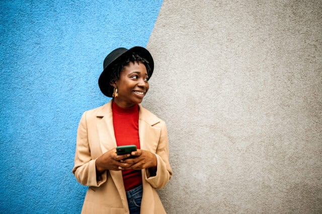 smiling woman standing against wall