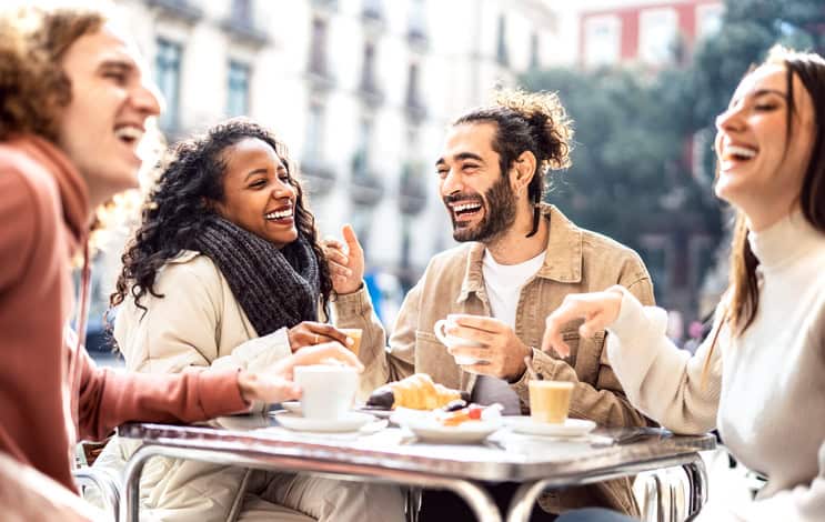 People group drinking cappuccino at coffee bar patio - Friends talking and having fun together at sidewalk cafeteria - Life style concept with happy men and women at cafe dehor - Warm bright filter