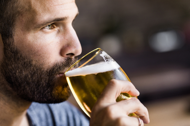 Close-up of man drinking beer.