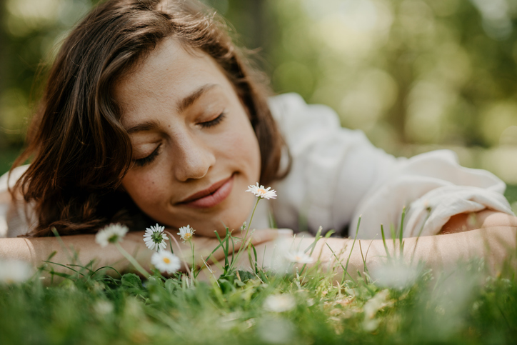 Happy woman laying in field of grass