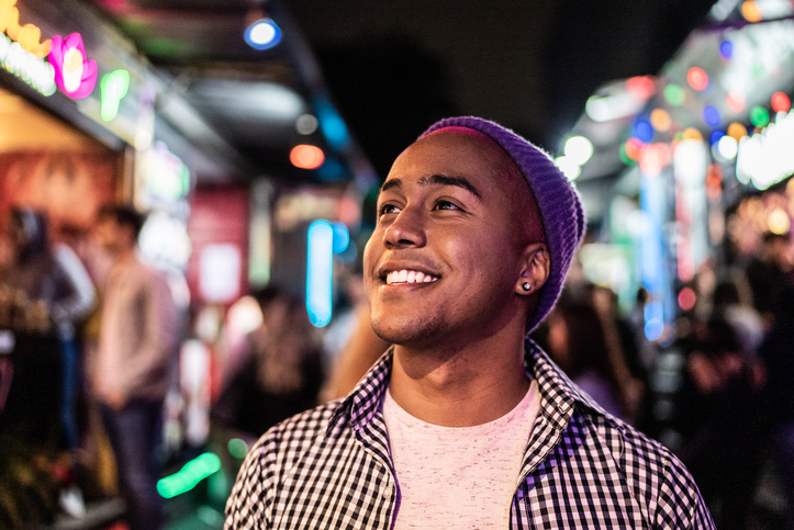 Young man smiling at a night market.