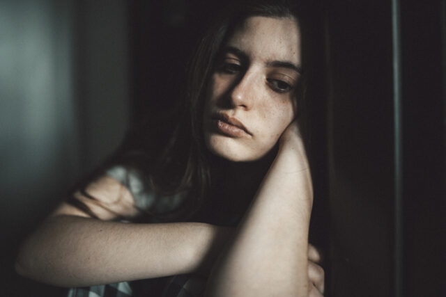 sad looking woman in shadows