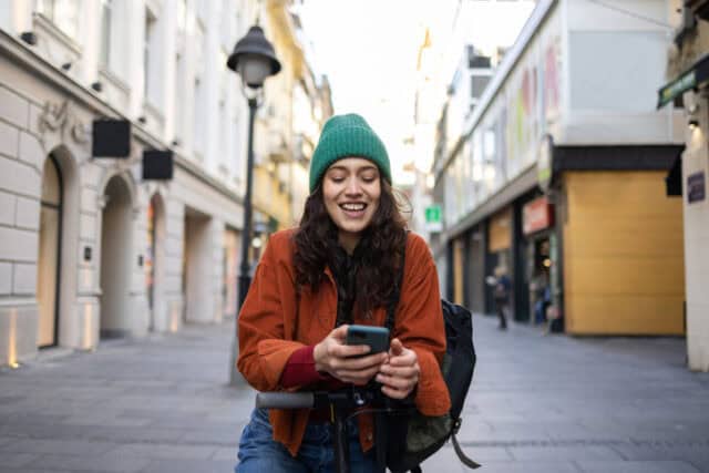 woman in beanie crouching in city