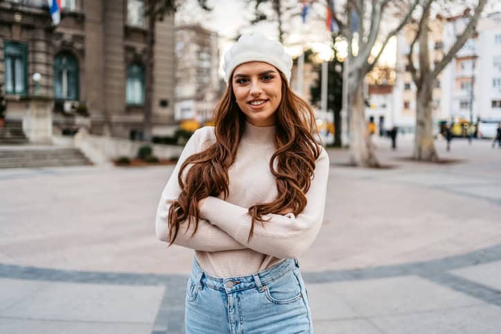 smiling woman arms crossed outside in winter