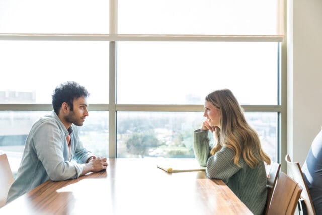 two people talking across a table
