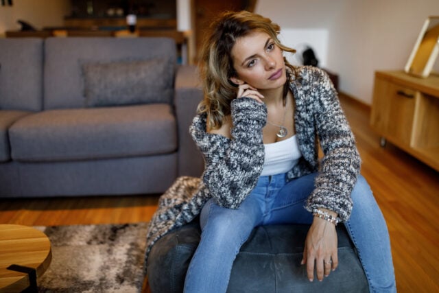 depressed woman sitting in her living room