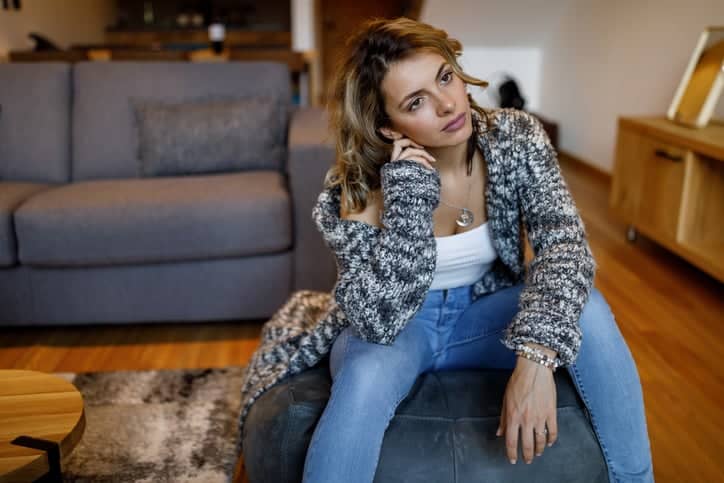 depressed woman sitting in her living room