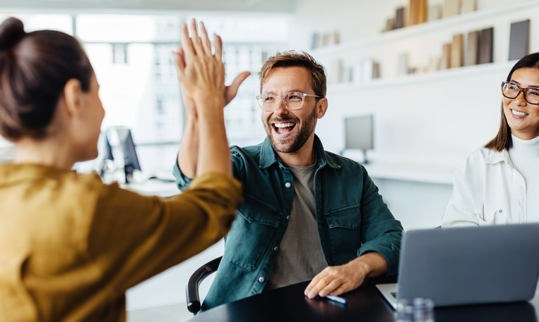 colleagues high-fiving in the office