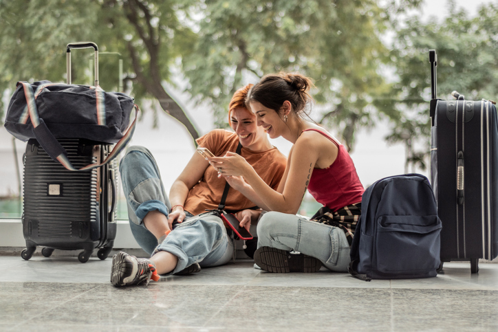 Two friends sitting at the airport.