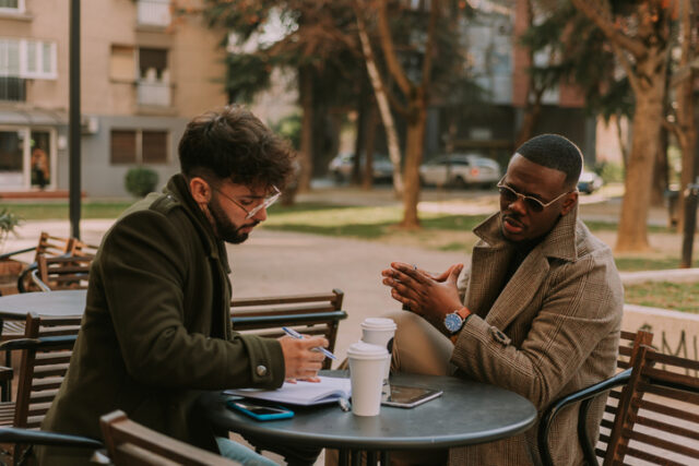 guy looking at phone while friend talks