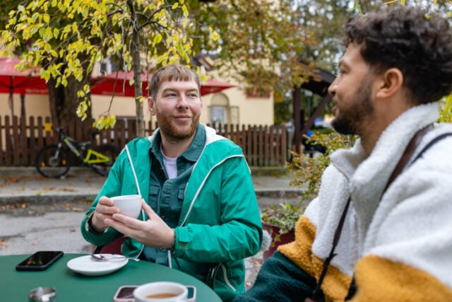 two men chatting at outdoor cafe