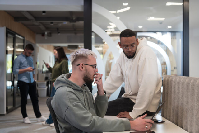 two male colleagues talking in office