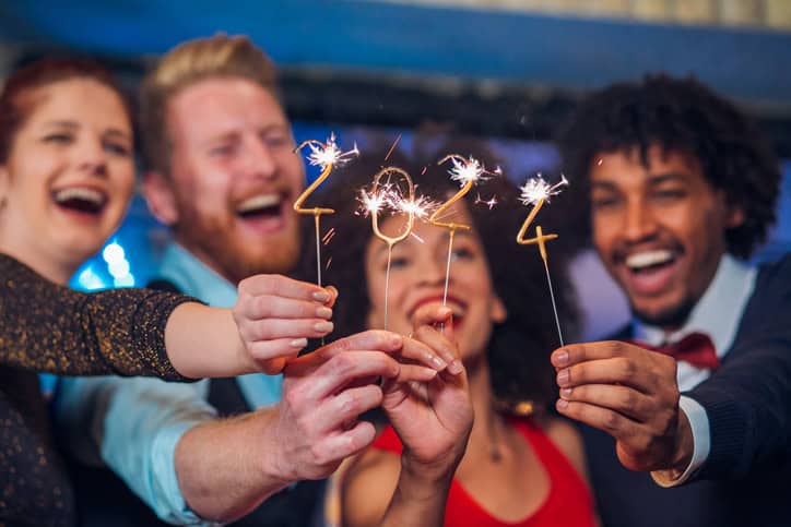 Young happy people looking at sparklers in their hands