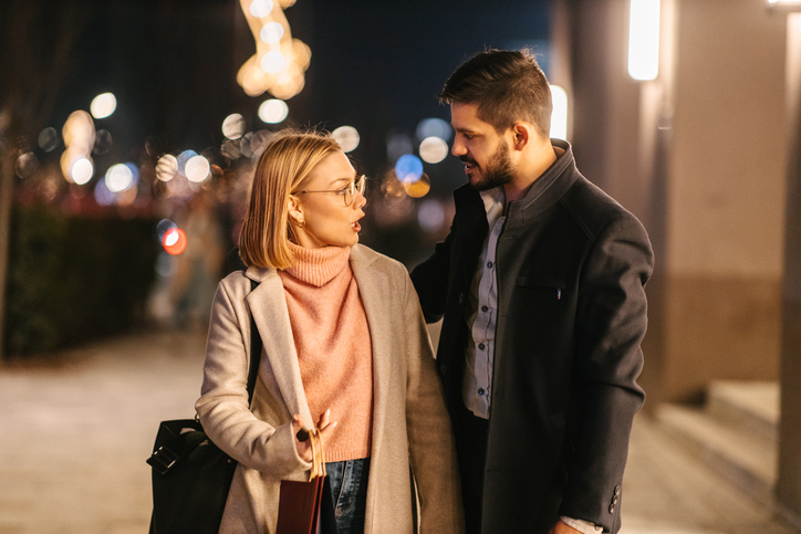 A well-dressed young couple arguing on the street