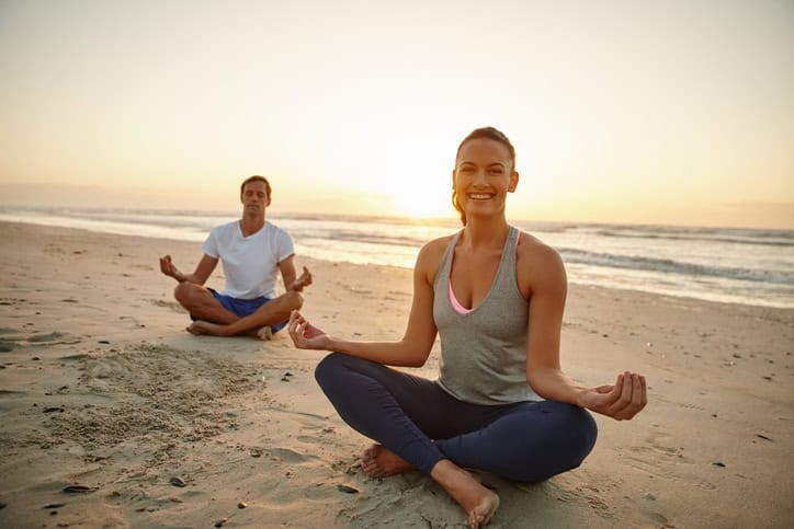 couple on a beach meditating