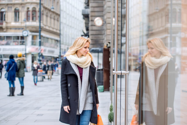 Beautiful young woman window shopping in historical centre of the city of Vienna, Austria. Winter.