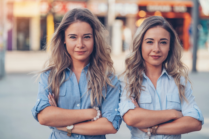 adult sisters with crossed arms