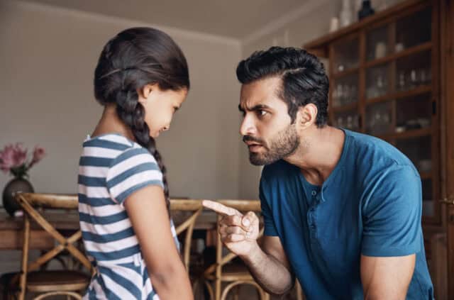 A dad scolding his mishcievious daughter.