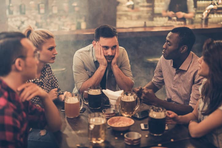 Upset guy out with group of friends.