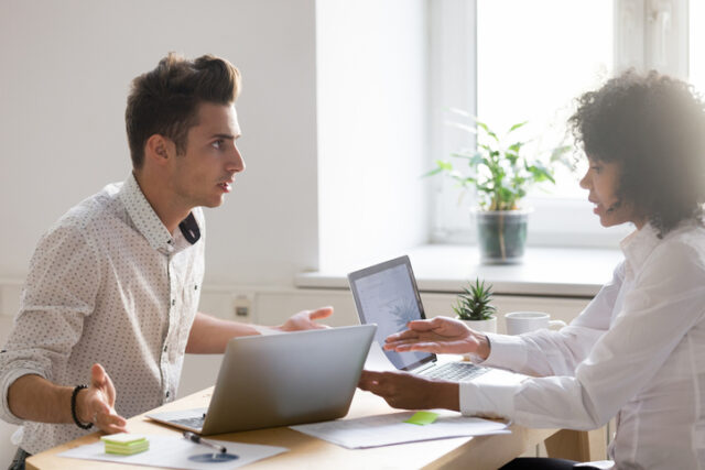 Multiracial colleagues argue about document disagree having conflict at work, diverse coworkers disputing about mistake in paperwork, african businesswoman blaming caucasian partner of bad contract