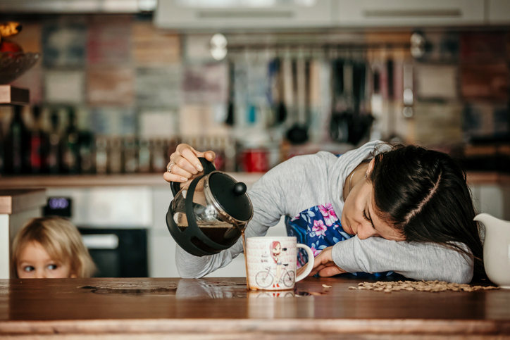 Tired mother pouring coffee in the morning.