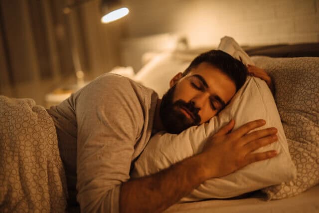 Man asleep in his bed.