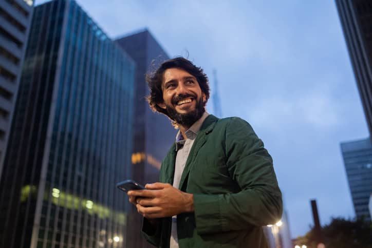 Young man using a smartphone at night.