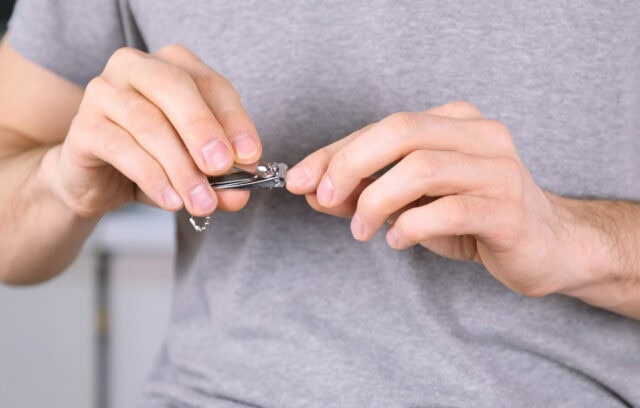Man using a nail clipper.
