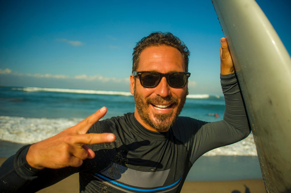 Man with a surf board at the ocean.