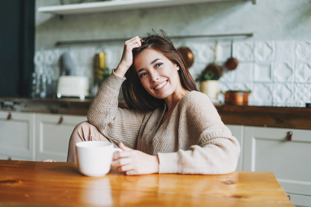 Woman cozy and happy to be staying in.