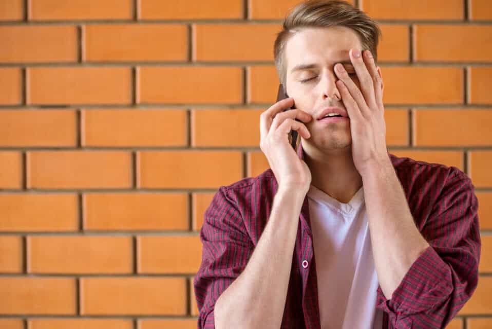 Young man frustrated on his phone.