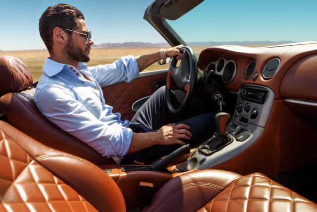 Man driving a nice car.